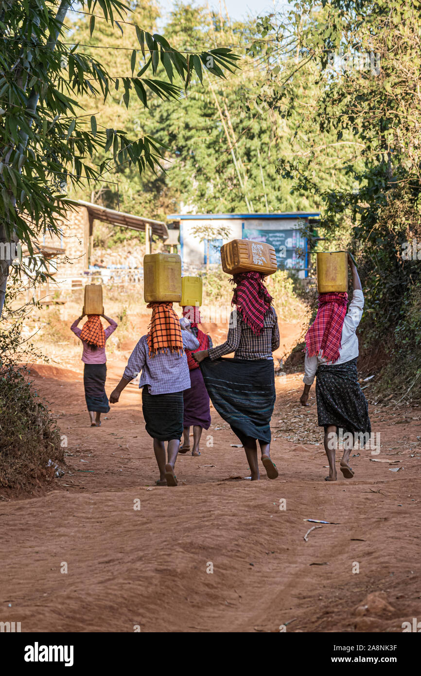 Die burmesische Frauen, die Wasser in hohen Dosen Stockfoto