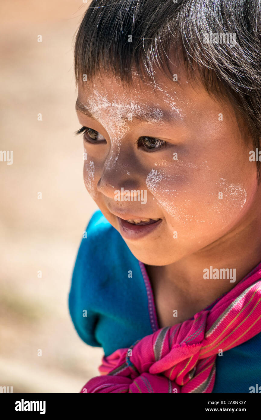 Kleine burmesische Kind mit thanaka-bemaltem Gesicht - ehrliches Porträt. Stockfoto