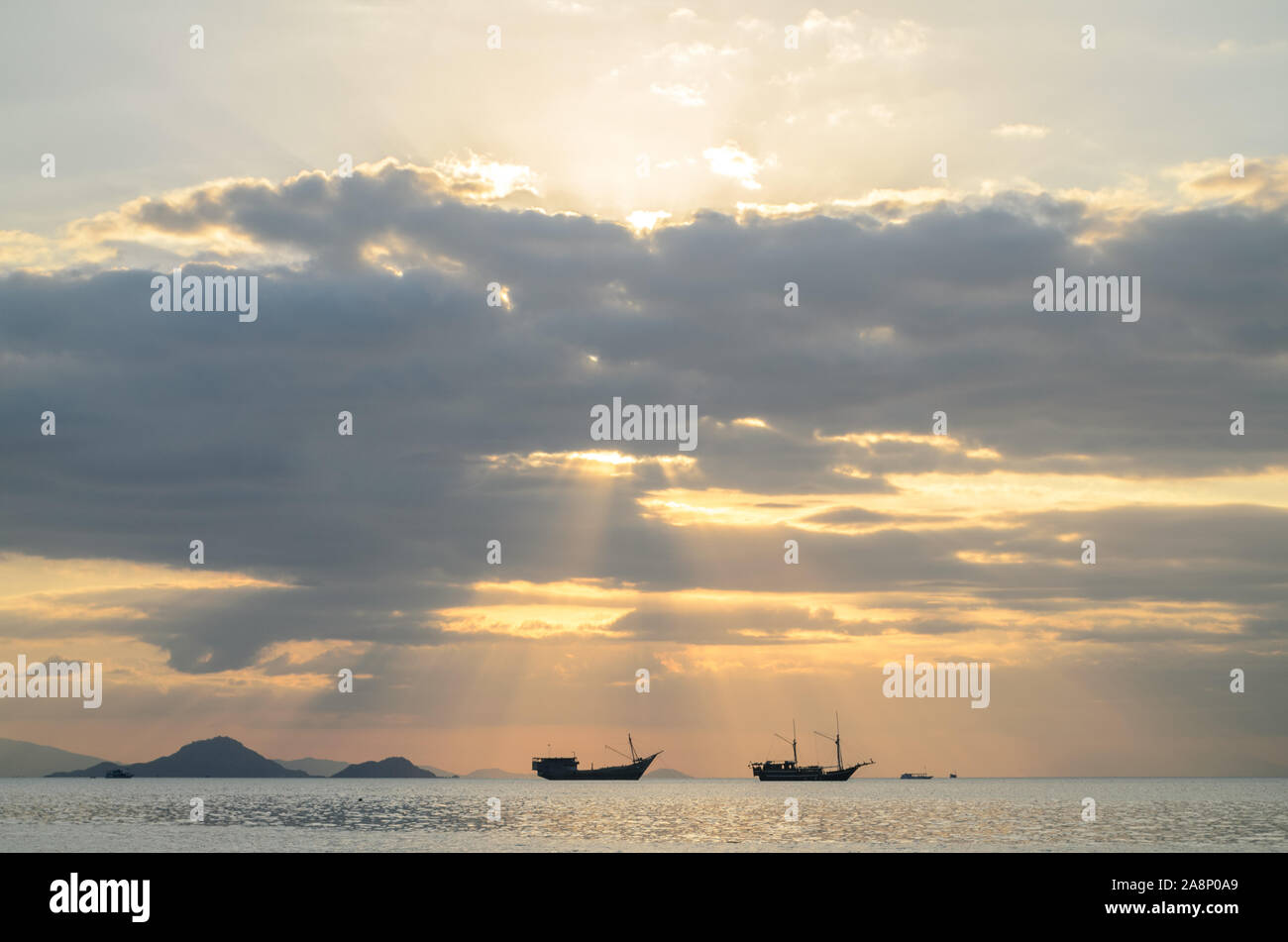 Sonnenuntergang in Labuan Bajo, Nusa Tenggara, Indonesien, mit Silhouette von zwei Custom Boot Stockfoto