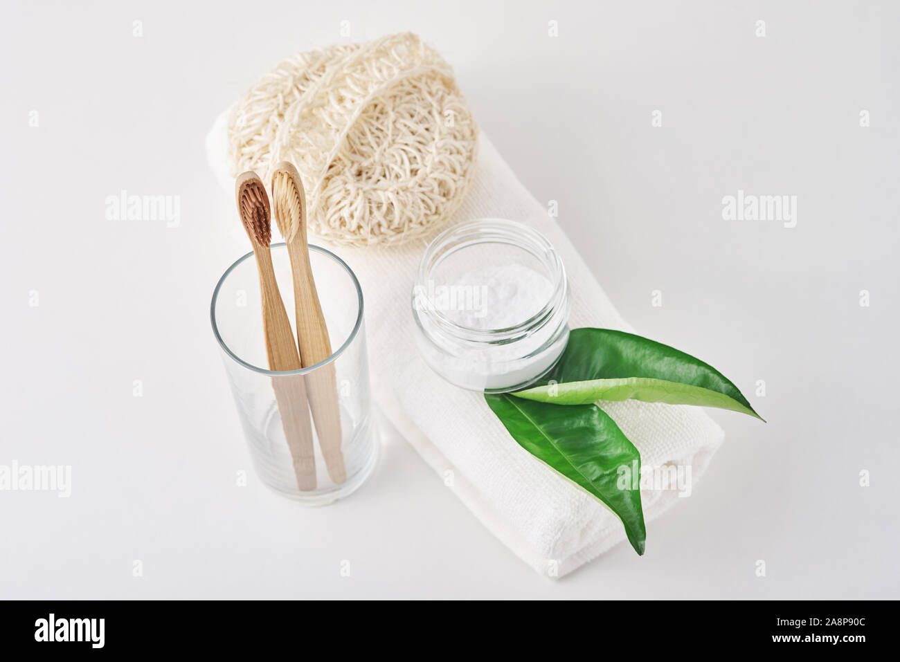 Holz Bambus Zahnbürsten in Glas, Natron und Handtuch auf weißem Hintergrund. Persönliche Hygiene Konzept Stockfoto