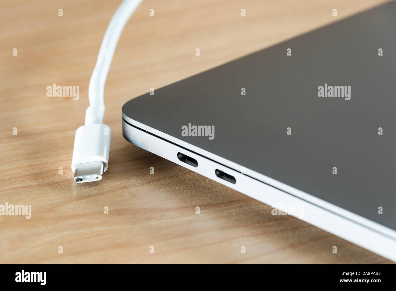 Ein USB-Kabel und USB-Typ C Typ C-Port an einem Laptop. Stockfoto