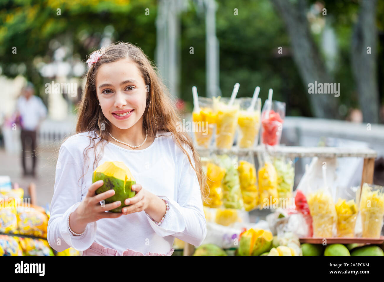 Schöne junge Mädchen am Paseo Bolivar Square in der Stadt Cali Essen tropische Früchte in Kolumbien Stockfoto