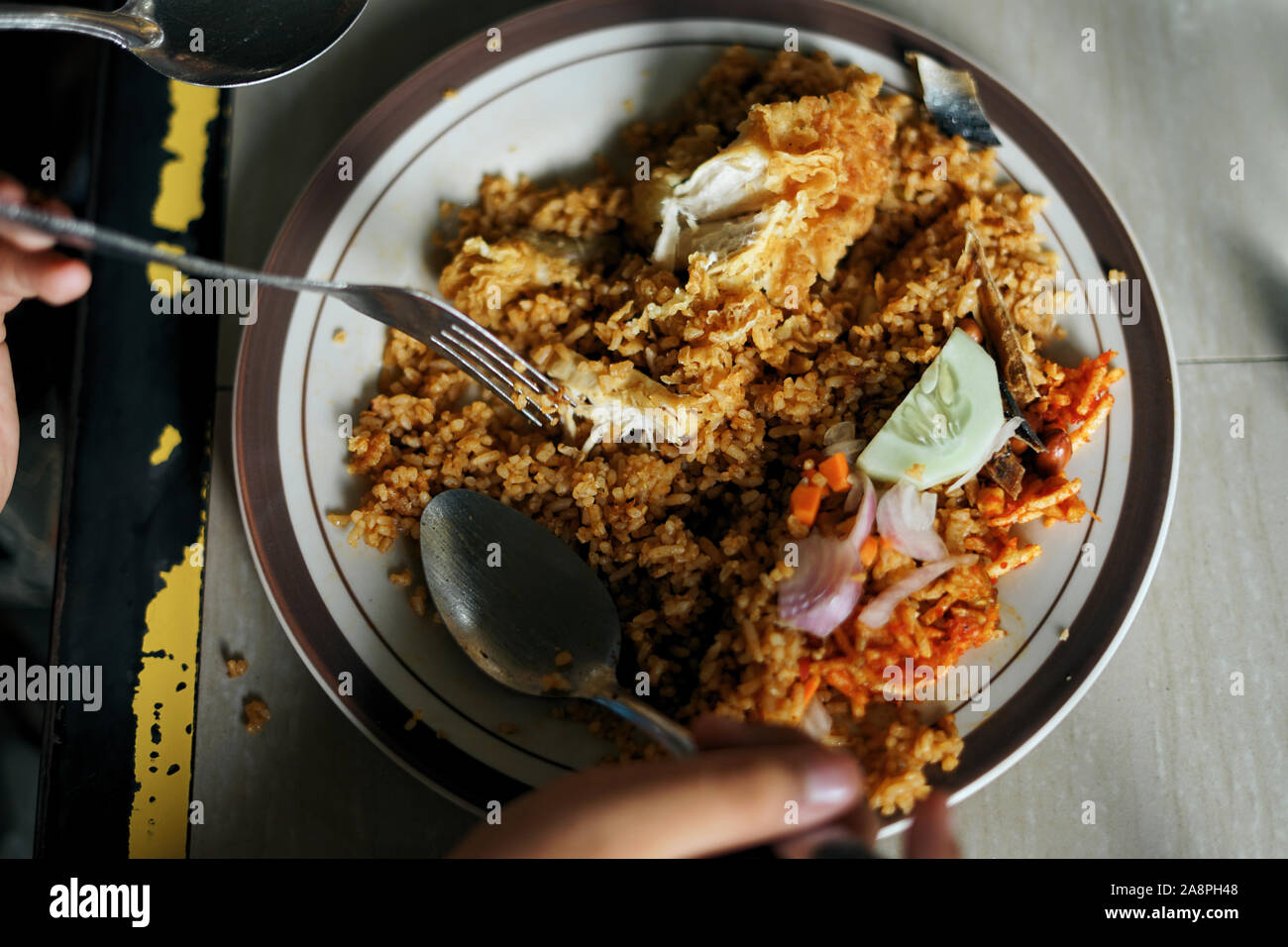 Kunden essen Nasi Goreng Ayam, Indonesische gebratener Reis an Street Food Markt Stockfoto