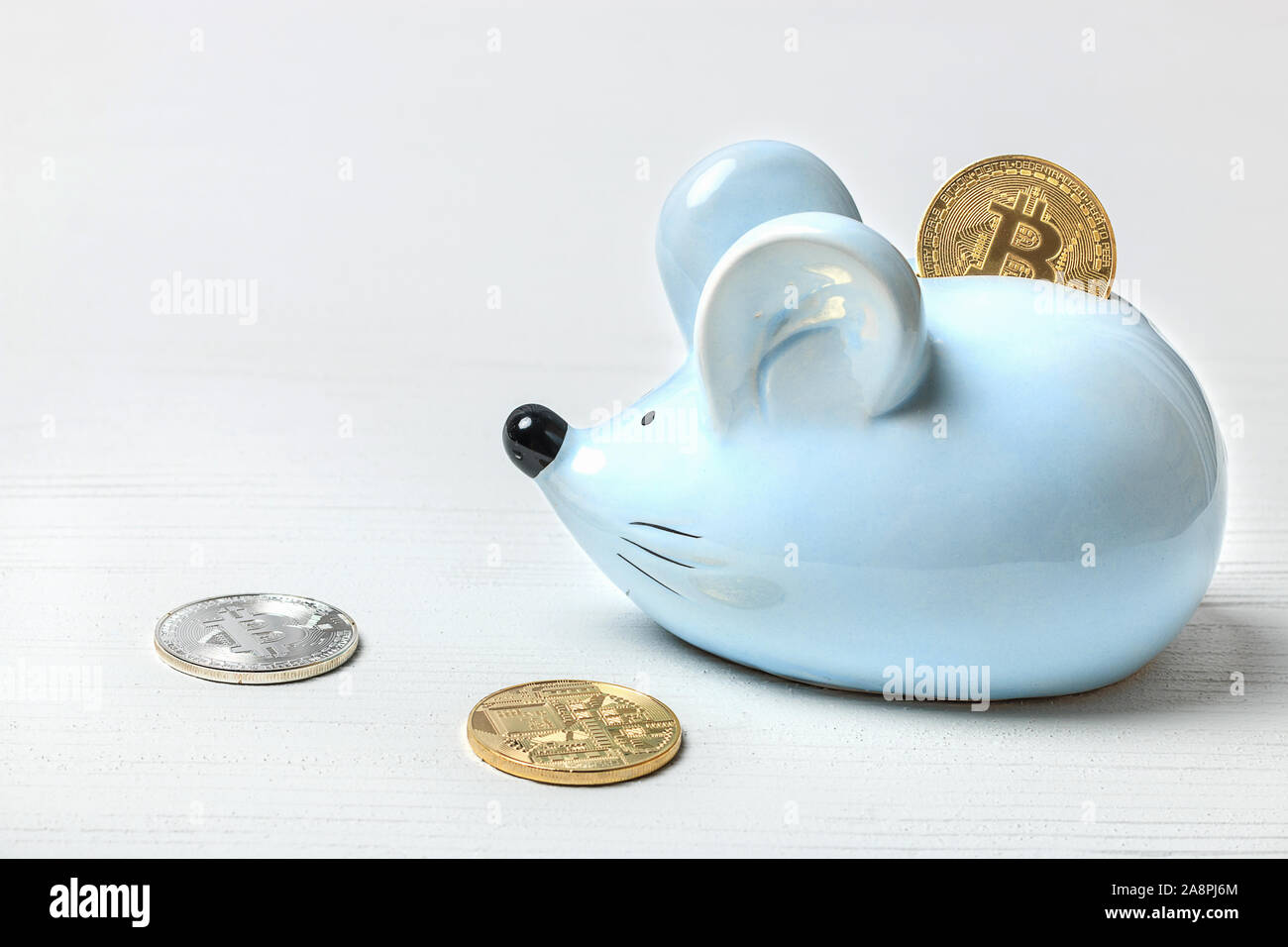 Blaue Maus oder Ratte Sparschwein auf weißem Hintergrund mit bitcoin Münzen. Konzept für Themen über Währungen und Finanzen, Horoskop und das neue Jahr 2020. Stockfoto