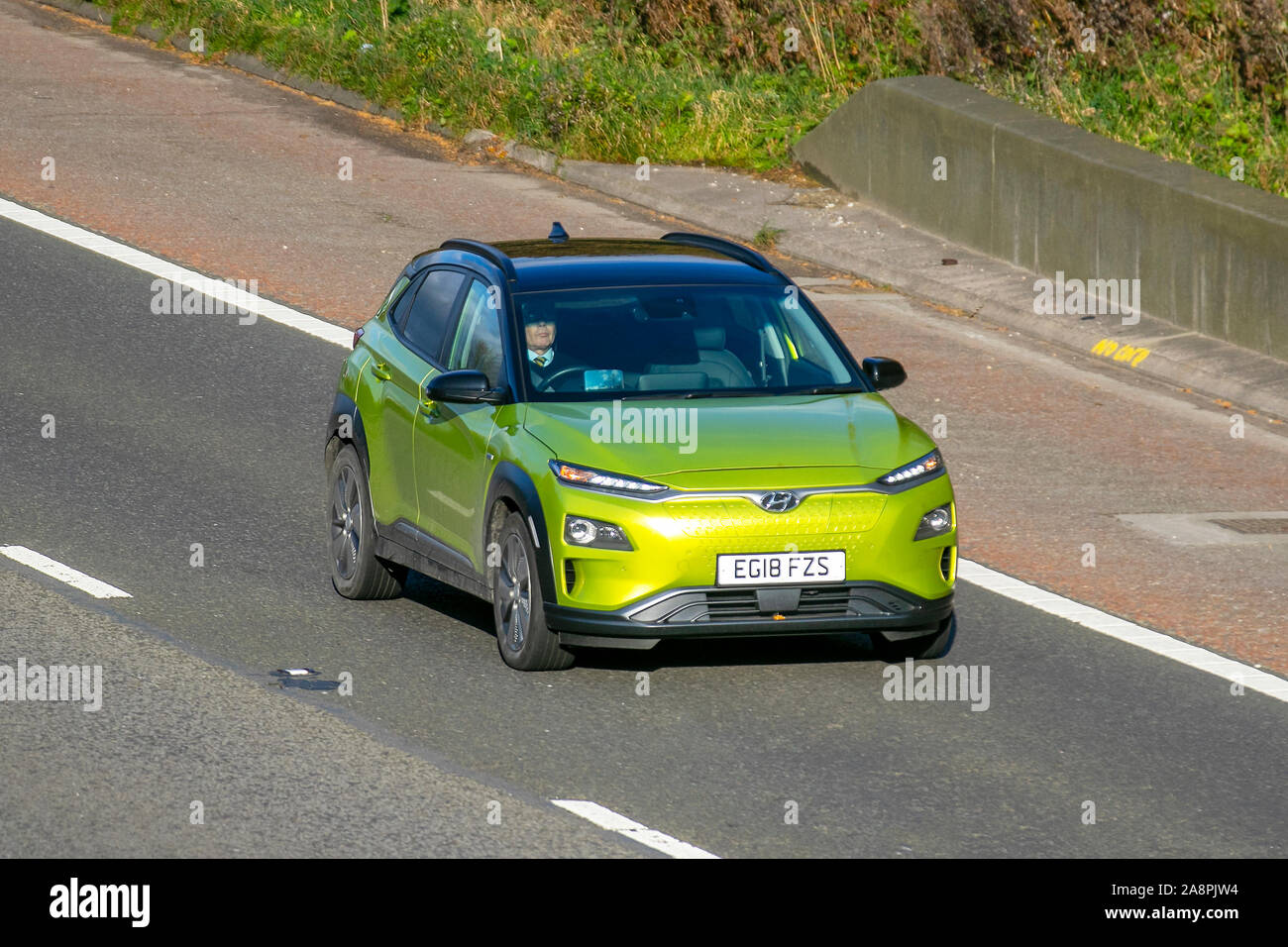 2018 gelbes Grün Hyundai Kona Premium SE EV Auto; UK Vehicular Traffic, Transport, moderne Fahrzeuge, Limousinen, EVS, elektrische Premium-Limousine, elektrische Limousine, Elektrofahrzeuge, Elektromotor, EV, Eigentümer eines Elektroautos, Richtung Süden auf der Autobahn 3, Spur M6. Stockfoto