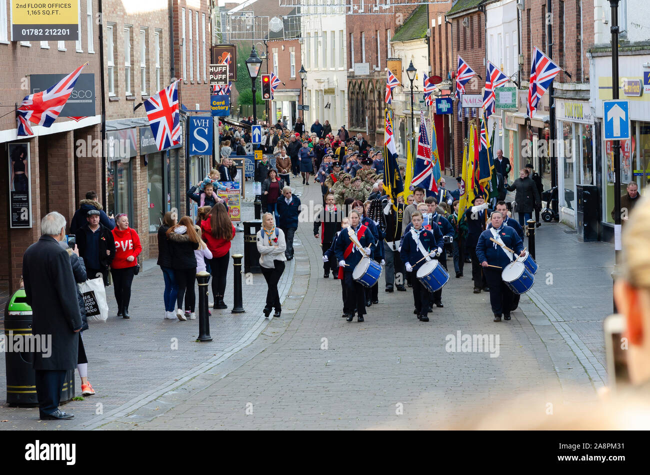 Foto von Kindern und Soldaten während der Erinnerung Tag der Parade in Stein, Staffordshire, Großbritannien marschieren. Stockfoto