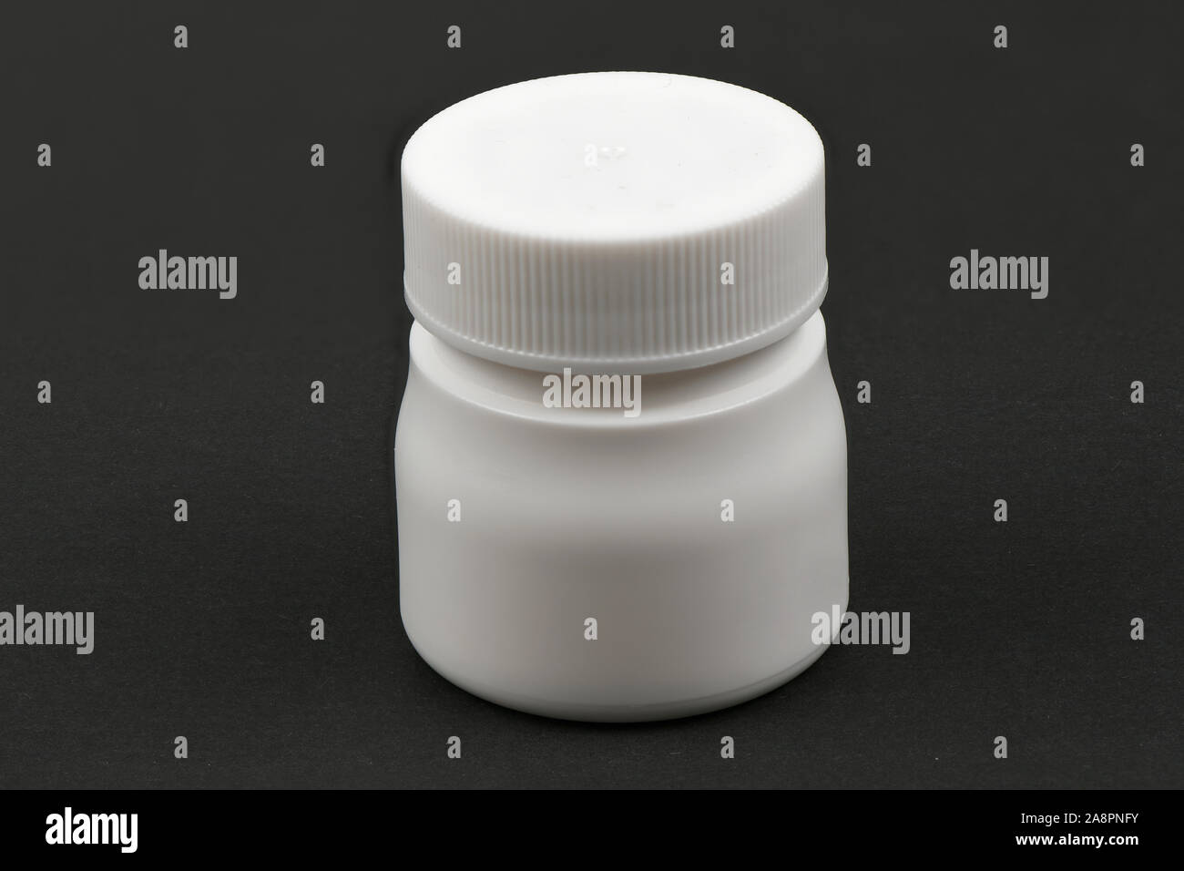 Weiße Pille Flasche auf schwarzem Hintergrund isoliert. Hochauflösendes Foto. Volle Tiefenschärfe. Stockfoto