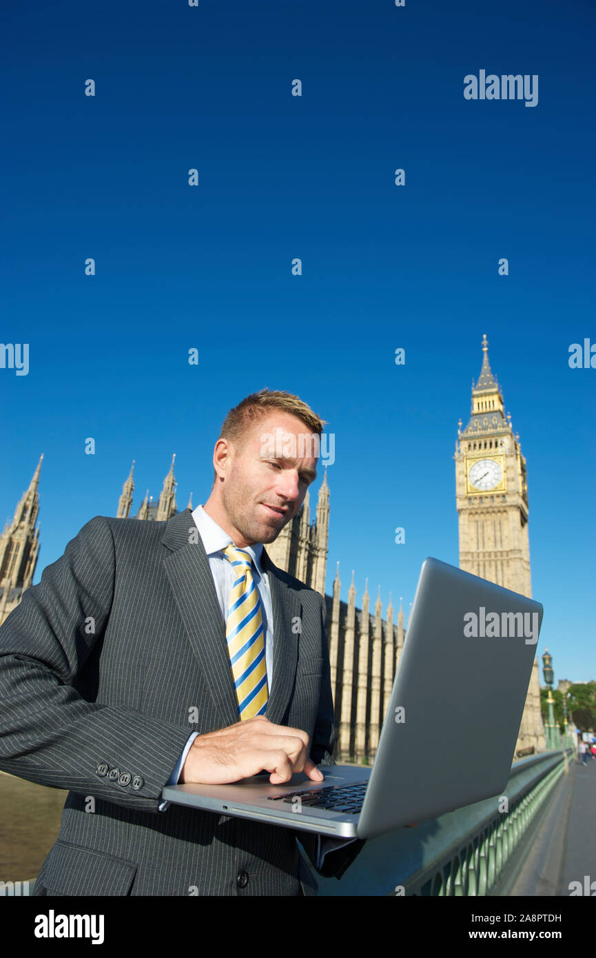 Britischer Politiker mit Laptop vor dem Parlamentsgebäude und Big Ben unter hellen sonnigen Himmel in London, Großbritannien Stockfoto