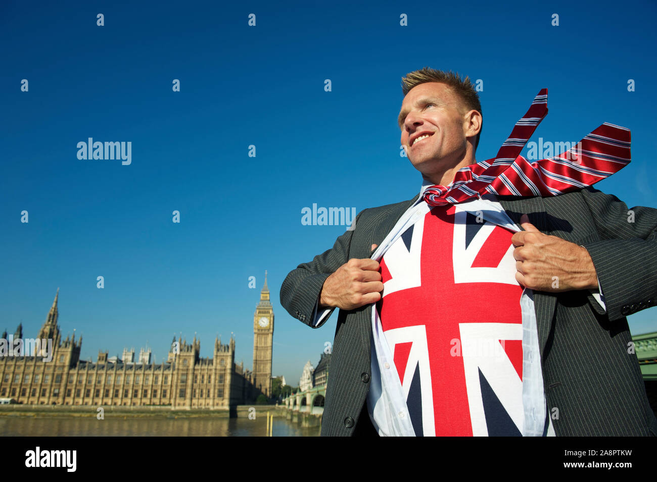 Lächelnd britischer Politiker ziehen geöffnet sein Anzug innere Union Jack Brexit Superhelden vor der Skyline von London in Westminster zu offenbaren Stockfoto