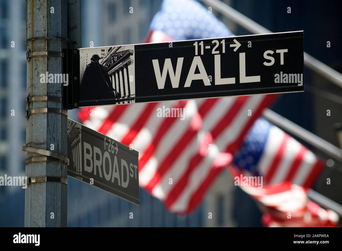 NEW YORK CITY - 7. AUGUST 2010: amerikanische Fahnen wehen hinter ein Zeichen für die Wall Street, das Symbol des amerikanischen Kapitalismus. Stockfoto