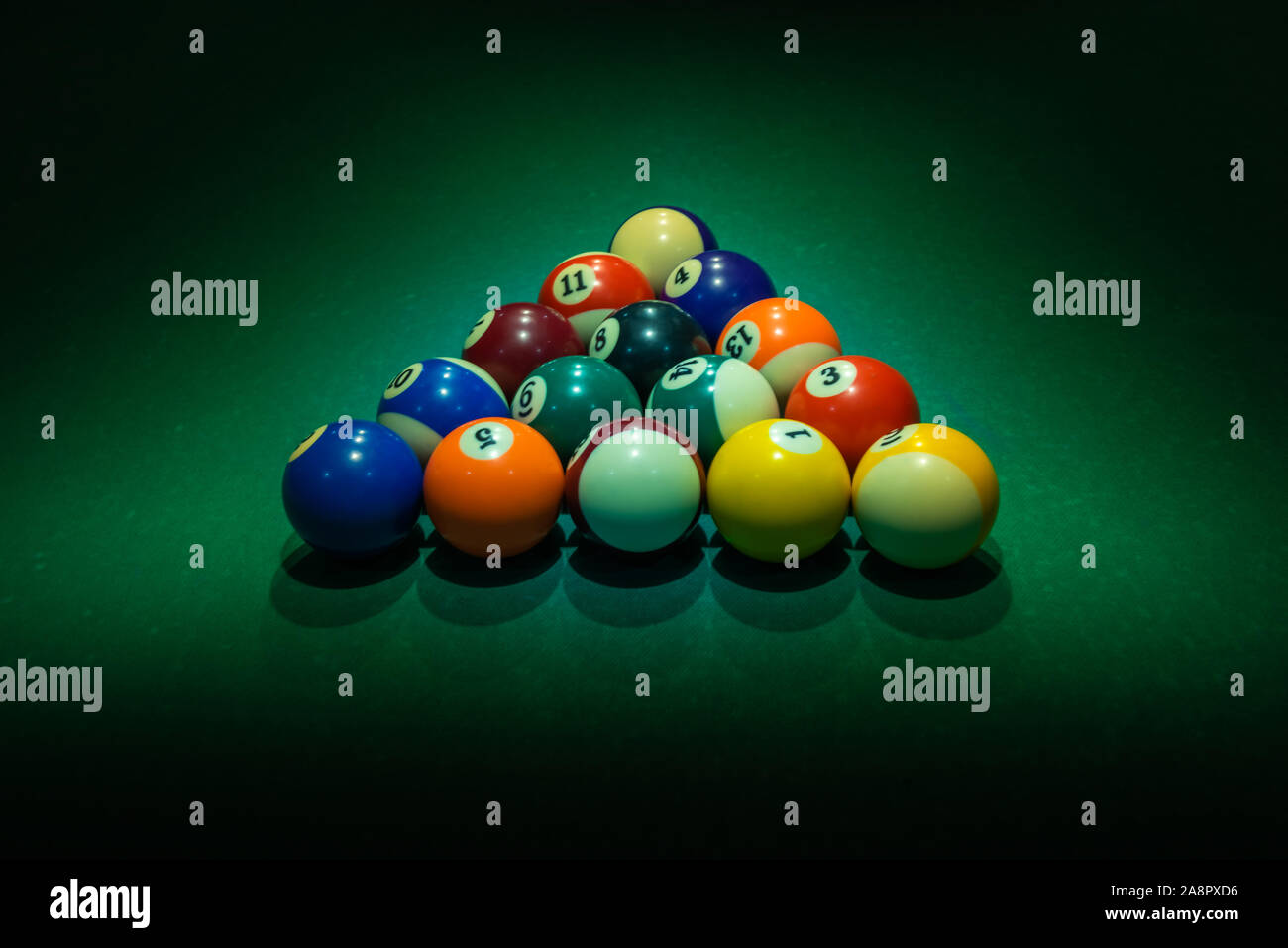 Bunte Nummern auf den Kugeln mit ihren Schattierungen bilden Dreieck am grünen Tisch. Horizontale Hintergrund mit Ausrüstung für Amerikanische Billardqueue sport ga Stockfoto