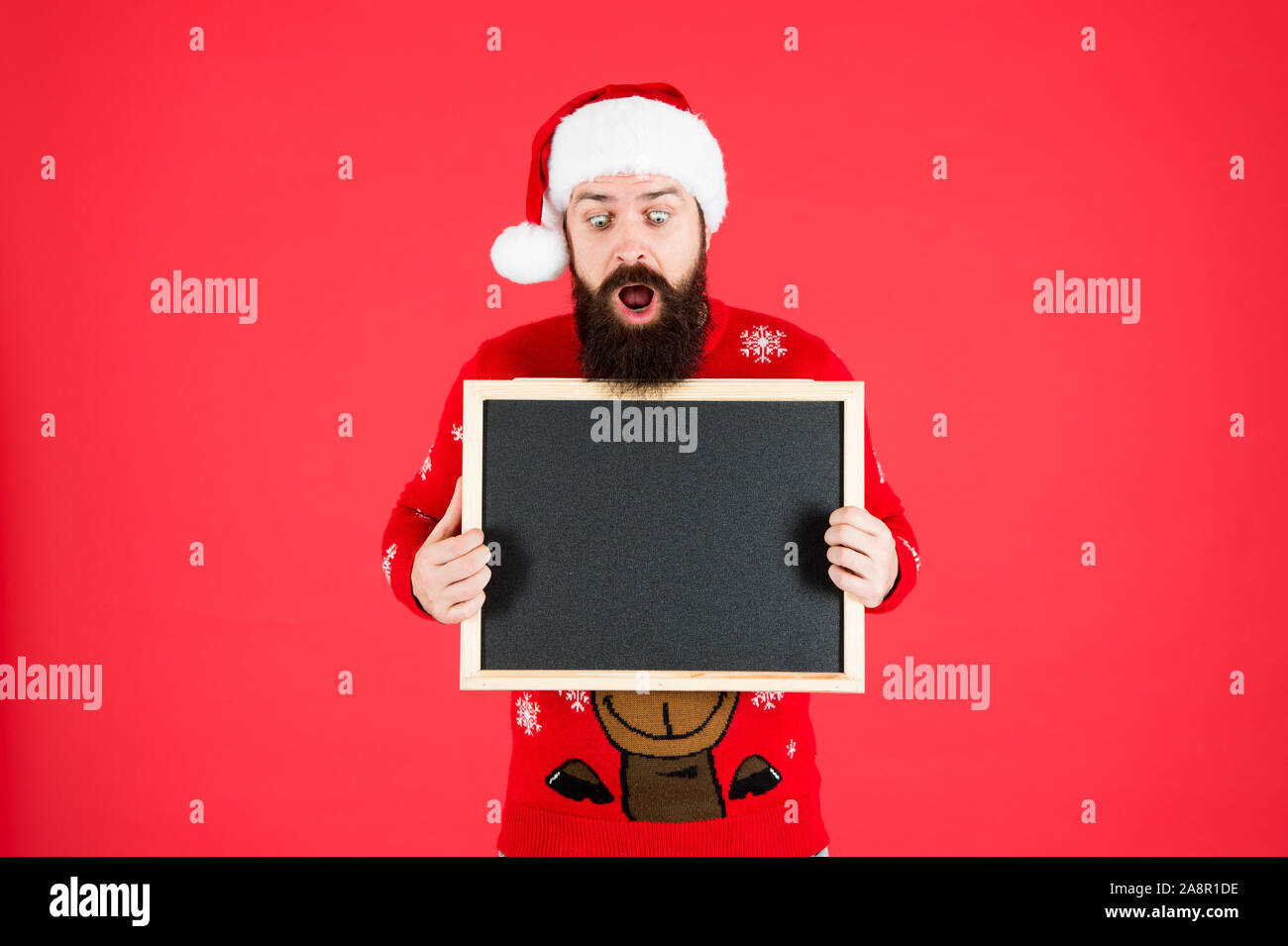 Unglaublich. Winter Ankündigung. Schwarzes Brett für Informationen. Mann leere Tafel kopieren. Guy santa claus roten Hintergrund. Winter event. Winterurlaub. Santa Claus hat mit Werbung. Stockfoto