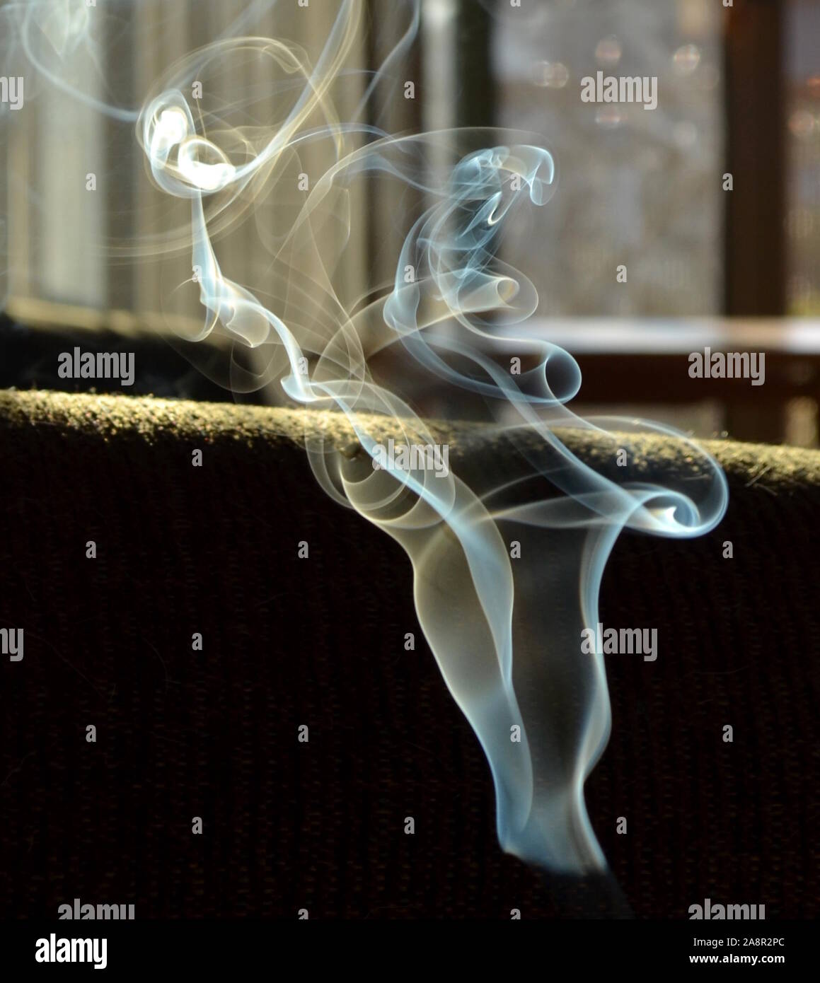 Räucherstäbchen Rauch locken und Bänder in der Luft. Stockfoto