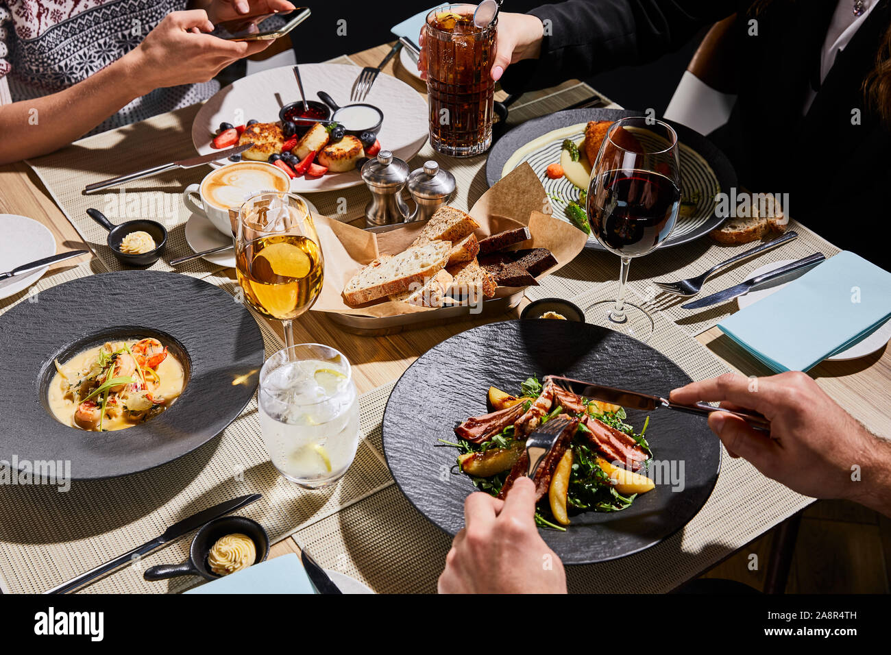 7/8-Ansicht von Menschen, köstliches Essen im Restaurant Stockfoto