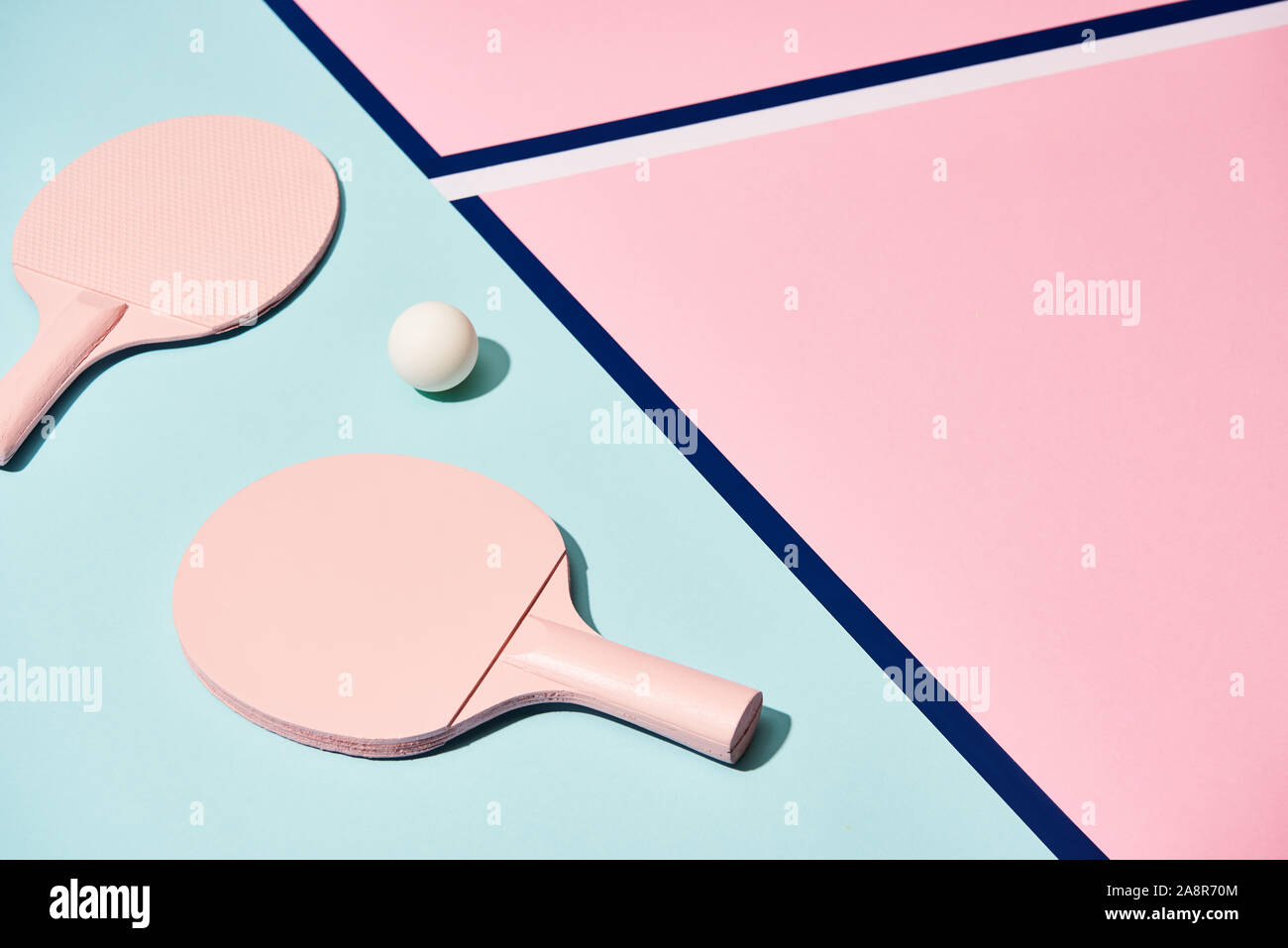Hohe Betrachtungswinkel von Ping pong Schläger und Ball auf Pastell Oberfläche mit blauen Linien Stockfoto