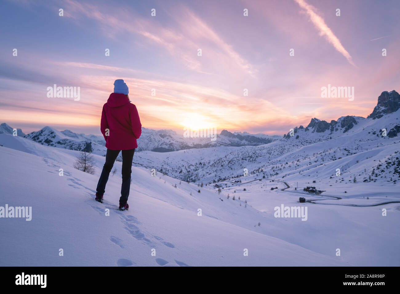 Junge Frau im verschneiten Berge bei Sonnenuntergang im Winter Stockfoto