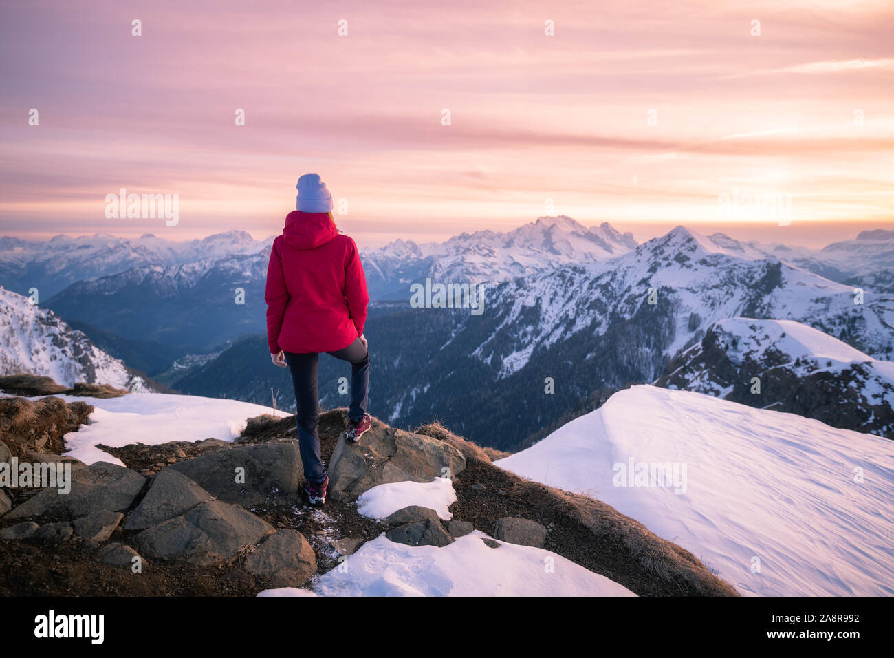 Junge Frau im verschneiten Berge bei Sonnenuntergang im Winter Stockfoto