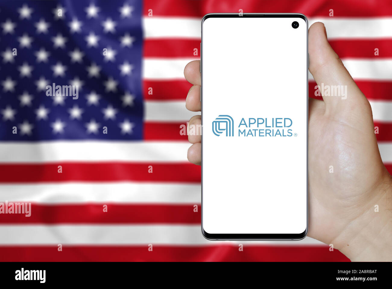 Logo der öffentlichen Unternehmen Applied Materials Inc. angezeigt auf einem Smartphone. Flagge der USA Hintergrund. Credit: PIXDUCE Stockfoto