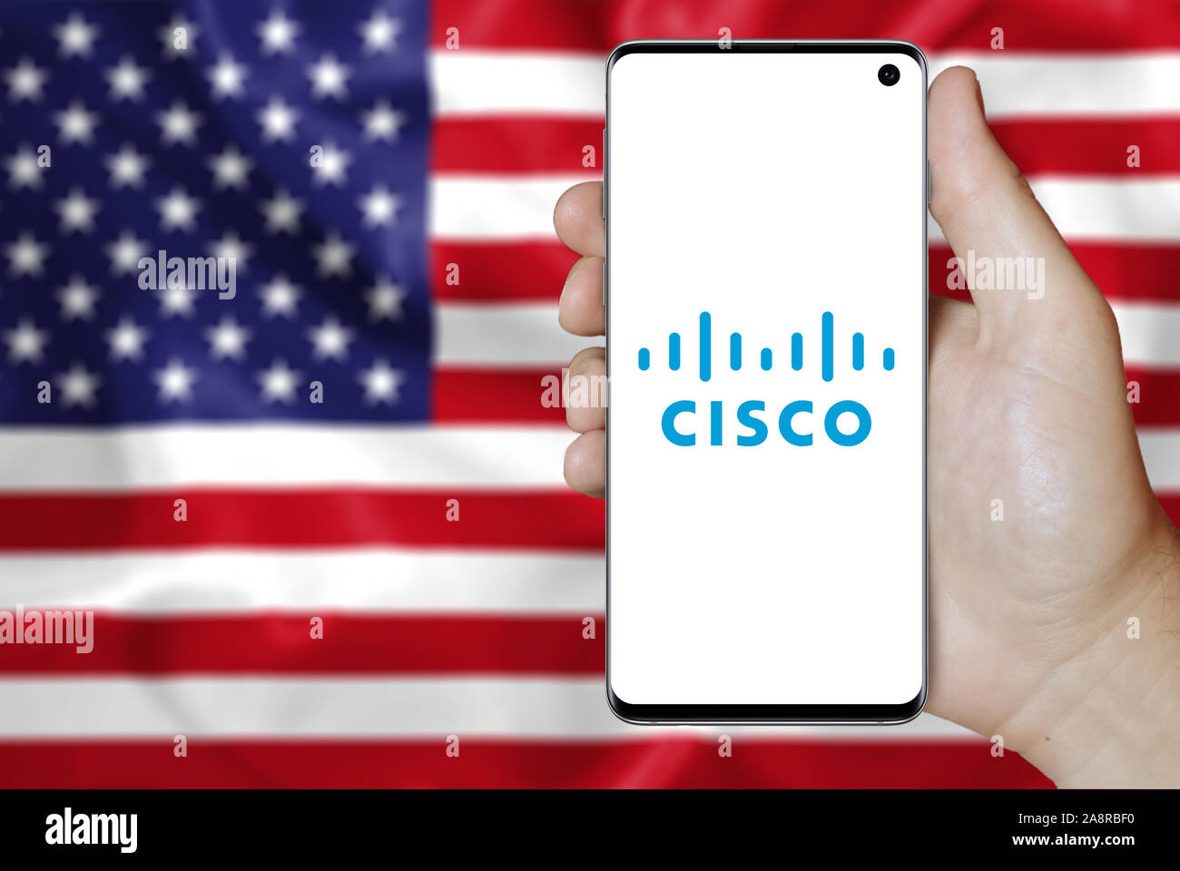 Logo der öffentlichen Unternehmen Cisco Systems auf dem Smartphone angezeigt. Flagge der USA Hintergrund. Credit: PIXDUCE Stockfoto
