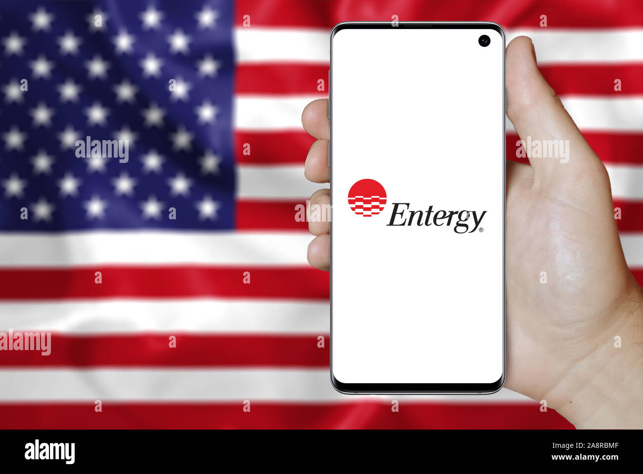 Logo der öffentlichen Gesellschaft Entergy Corp. auf dem Smartphone angezeigt. Flagge der USA Hintergrund. Credit: PIXDUCE Stockfoto