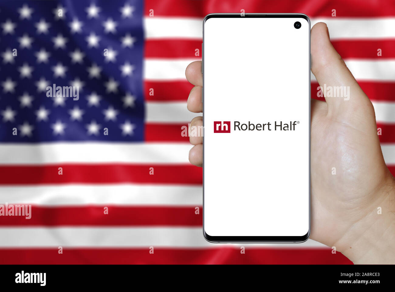 Logo der öffentlichen Unternehmen Robert Half International auf dem Smartphone angezeigt. Flagge der USA Hintergrund. Credit: PIXDUCE Stockfoto