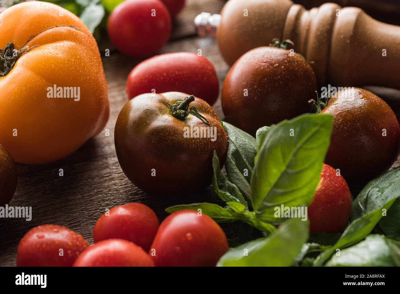 In der Nähe von Tomaten mit Spinat in der Nähe von Salz Mühle auf Holz- Oberfläche Stockfoto