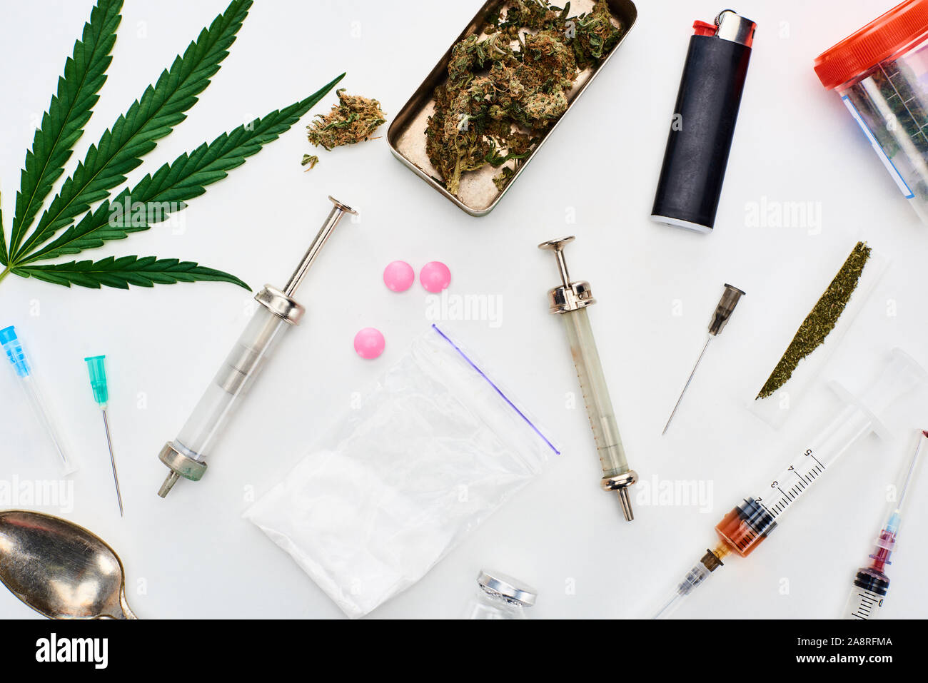 Blick von oben auf die Knospen, Cannabis leaf Marihuana, Heroin, Pillen und Spritzen auf weißem Hintergrund Stockfoto