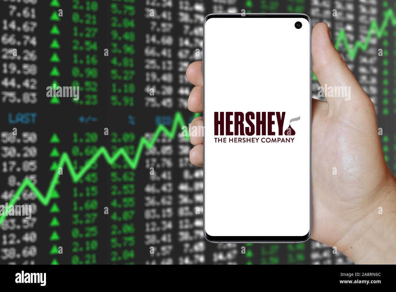 Logo der öffentlichen Unternehmen der Hershey Company auf einem Smartphone. Positive Börse Hintergrund. Credit: PIXDUCE Stockfoto