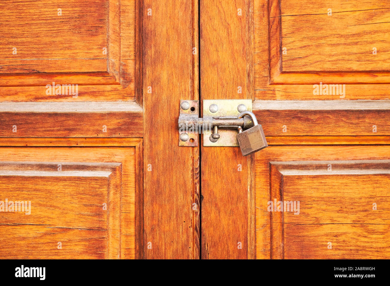Schöne Holz Tür oben mit einer Schraube und einem Vorhängeschloss gesichert. Stockfoto