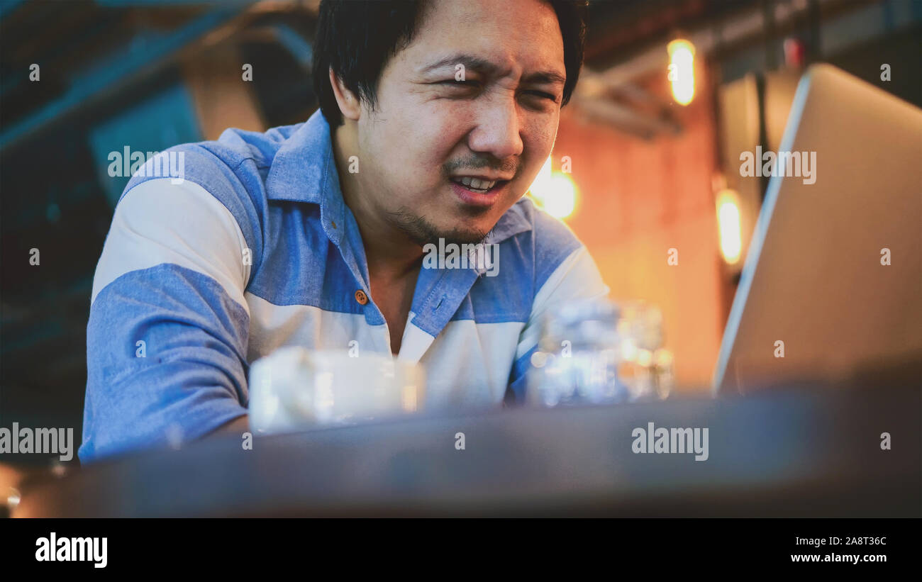 Asiatische Geschäftsmann in lässiger Anzug arbeiten mit Computer im Stress Emotion bei co-working space, Business in betätigen und betonte Konzept Stockfoto