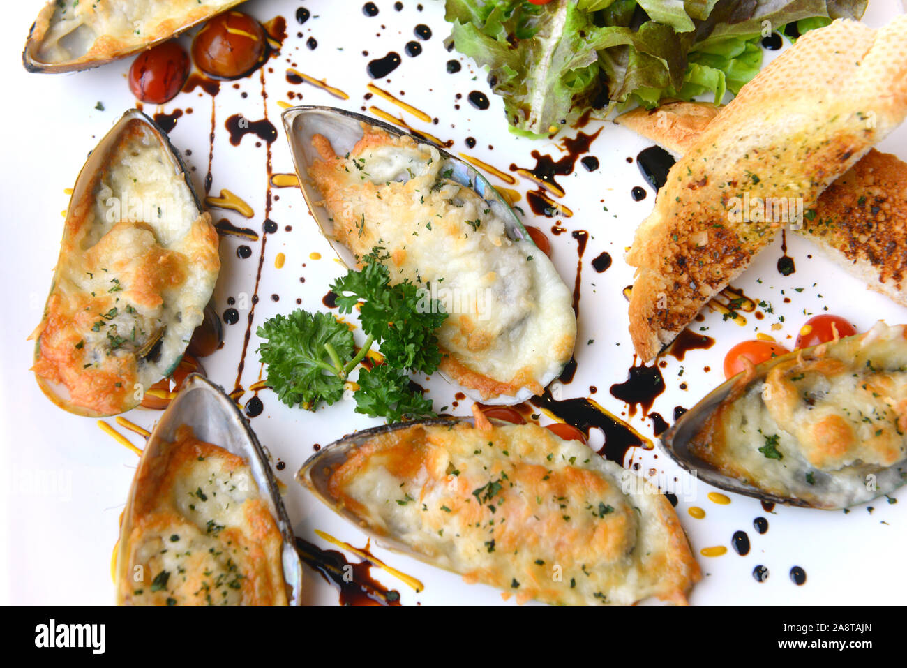 Fisch und Meeresfrüchte. Gebackene Neuseeland Muscheln mit Käse auf weißem Hintergrund Stockfoto