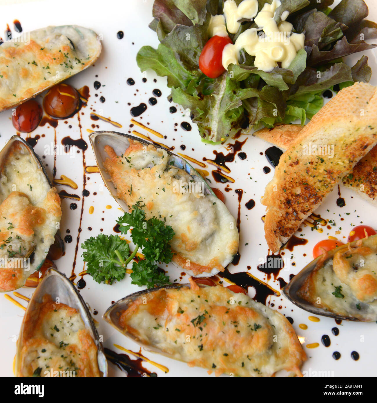 Fisch und Meeresfrüchte. Gebackene Neuseeland Muscheln mit Käse auf weißem Hintergrund Stockfoto