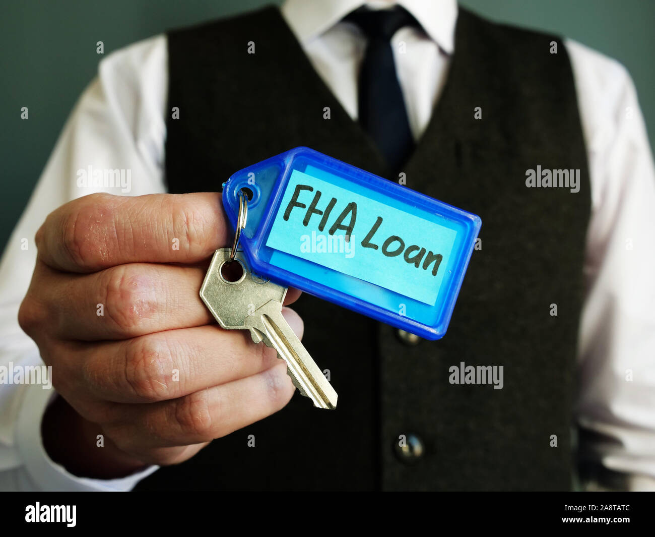 Der Schlüssel mit FHA Darlehen Zeichen ist in den Händen eines Mannes. Stockfoto