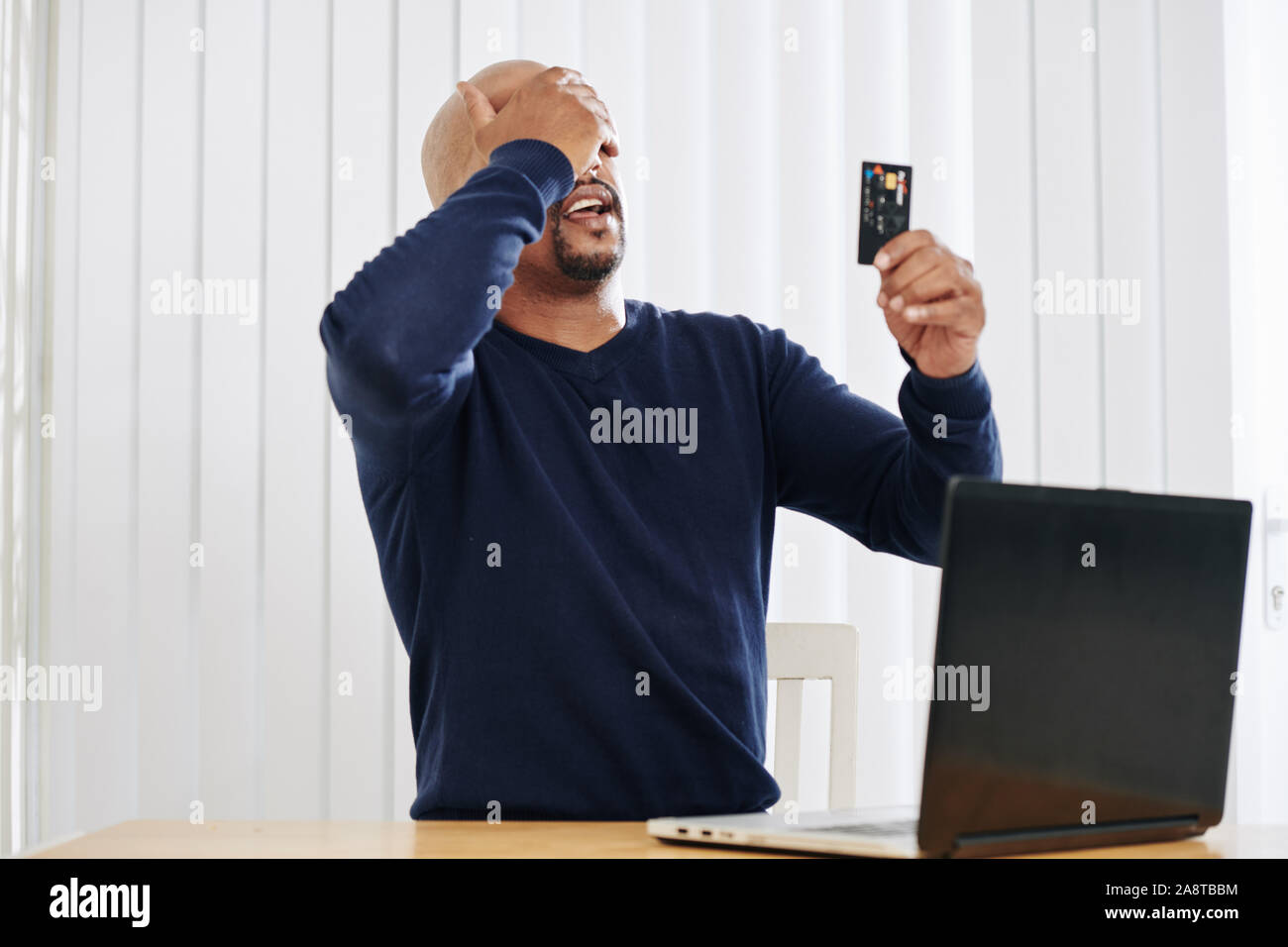 Mann mittleren Alters zu Gesicht palm Geste, als er erkannte, dass seine Kreditkarte gesperrt ist Stockfoto