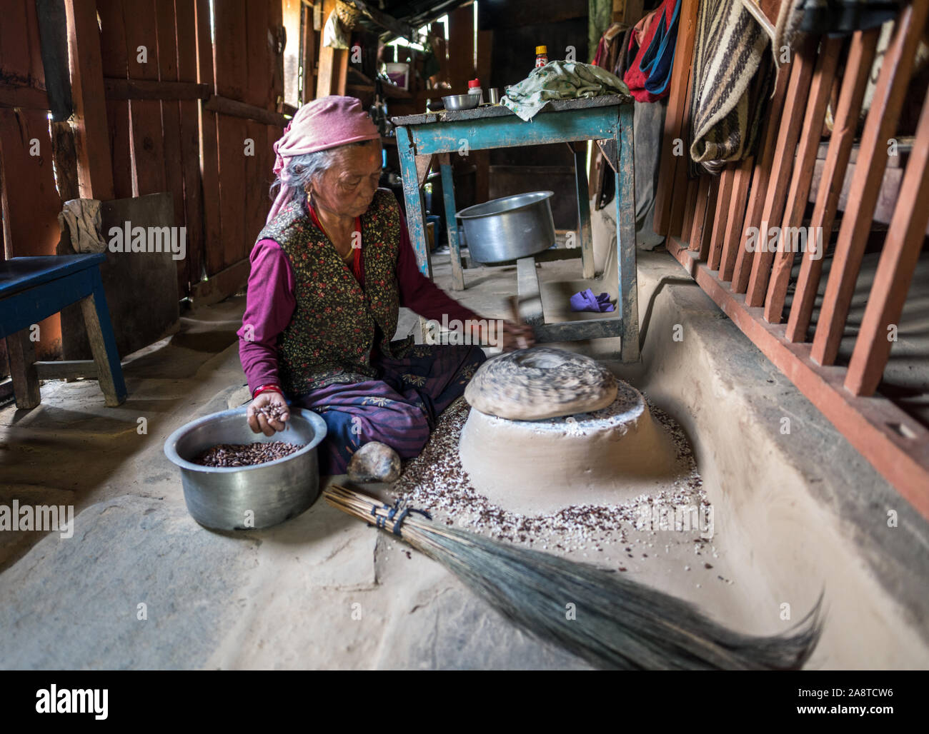 Nepali Frau mit hand Mühle Ghara, Annapurna Conservation Area, Nepal. Stockfoto