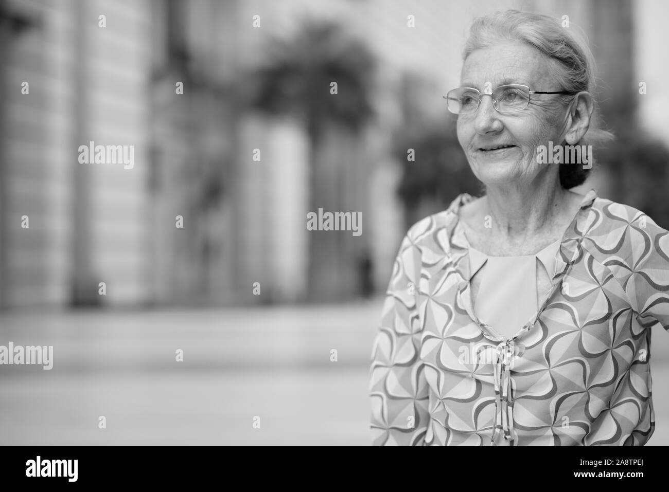 Schöne senior touristische Frau entspannende rund um die Stadt in Schwarz und Weiß Stockfoto