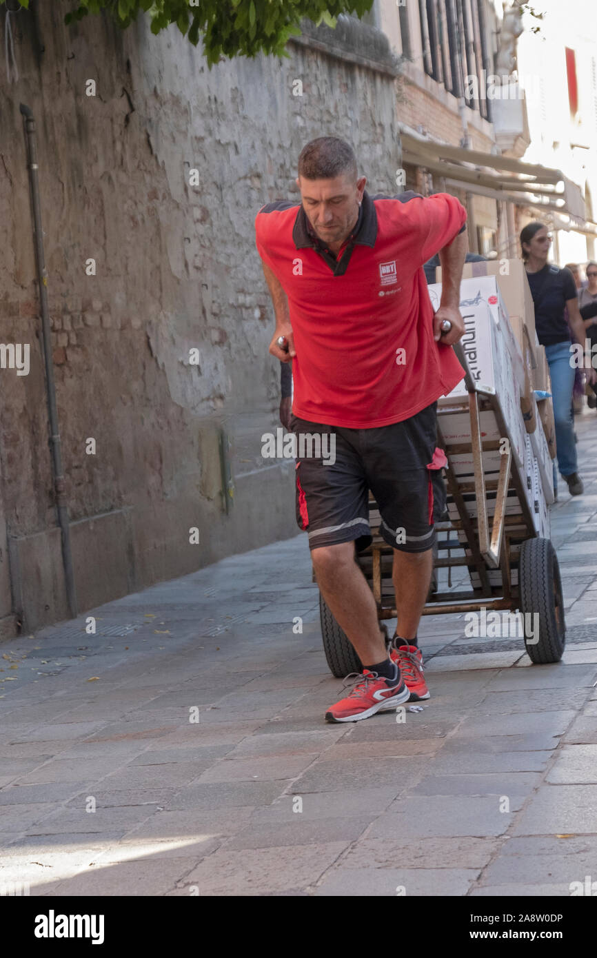 Ein Arbeiter liefert Pakete von Hand in Venedig, Italien, eine Stadt ohne Autoverkehr. Stockfoto