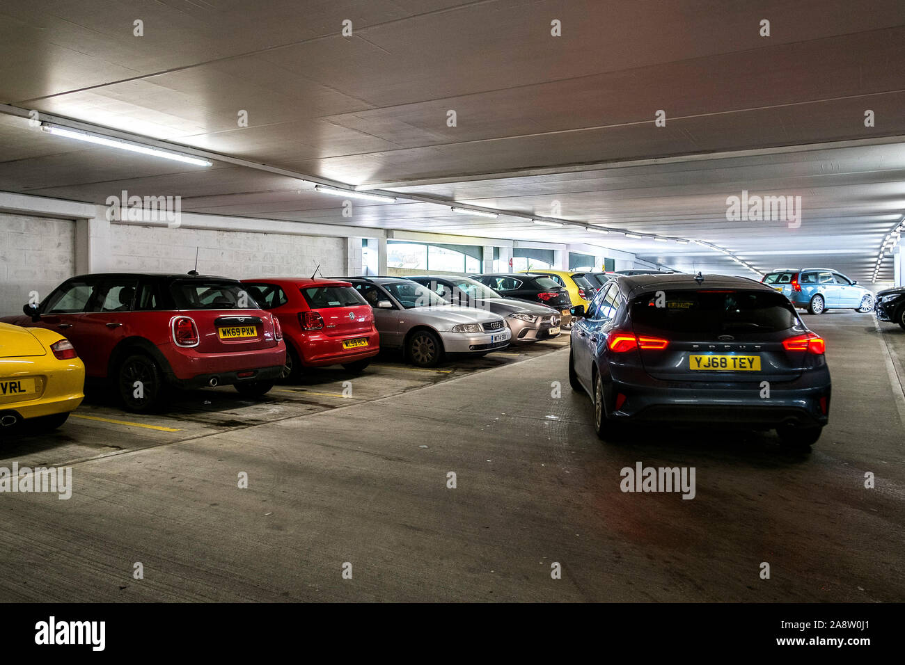 Autos für Parkplätze in einem überfüllten besetzt mehrstöckiges Parkhaus City Center in Truro in Cornwall suchen. Stockfoto