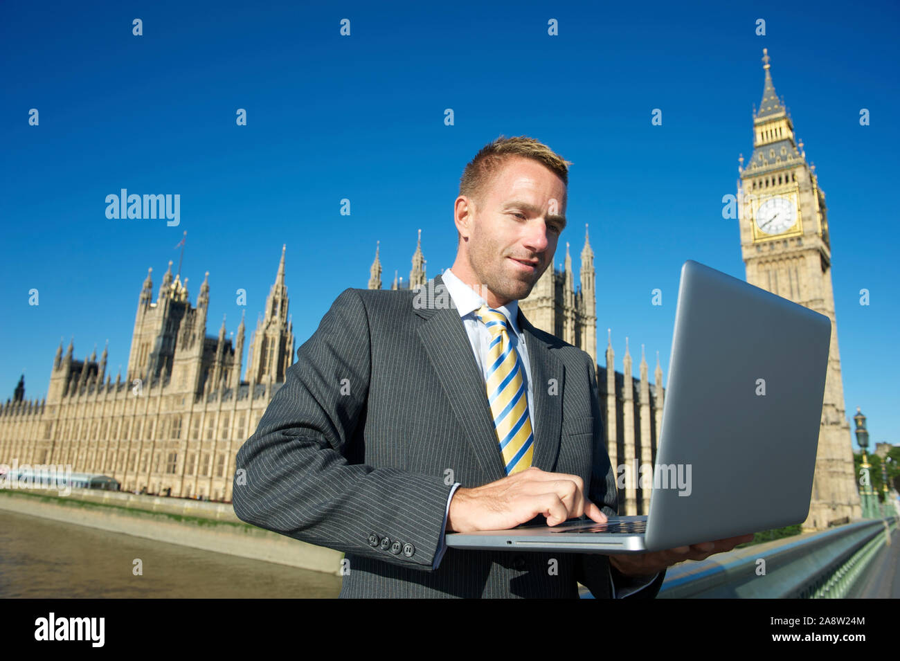 Britischer Politiker mit Laptop vor dem Parlamentsgebäude und Big Ben unter hellen sonnigen Himmel in London, Großbritannien Stockfoto