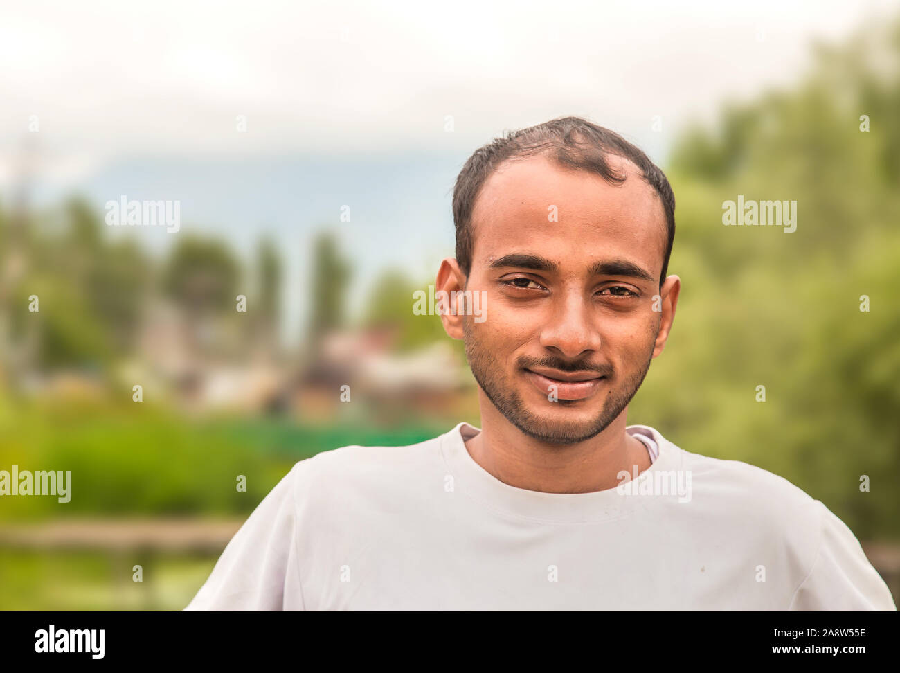 Closeup headshot Porträt, glücklich, gut aussehender Inder, entspannende außerhalb der Natur Szene während der sonnigen Tag Stockfoto