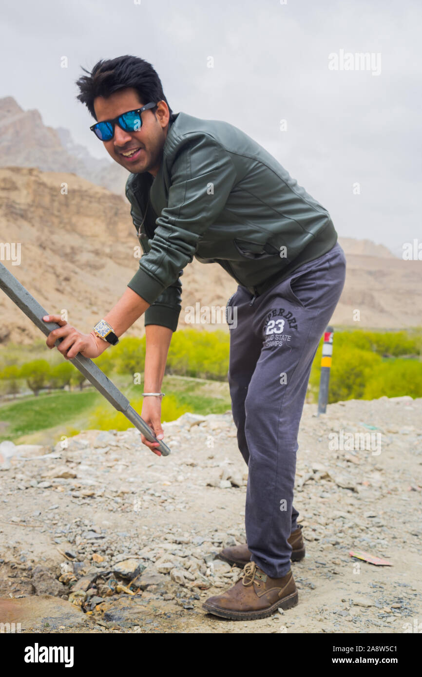 Durstig indische Touristen das Pumpen von Wasser aus der Hand Pumpe bei Leh Ladakh Region. Stockfoto