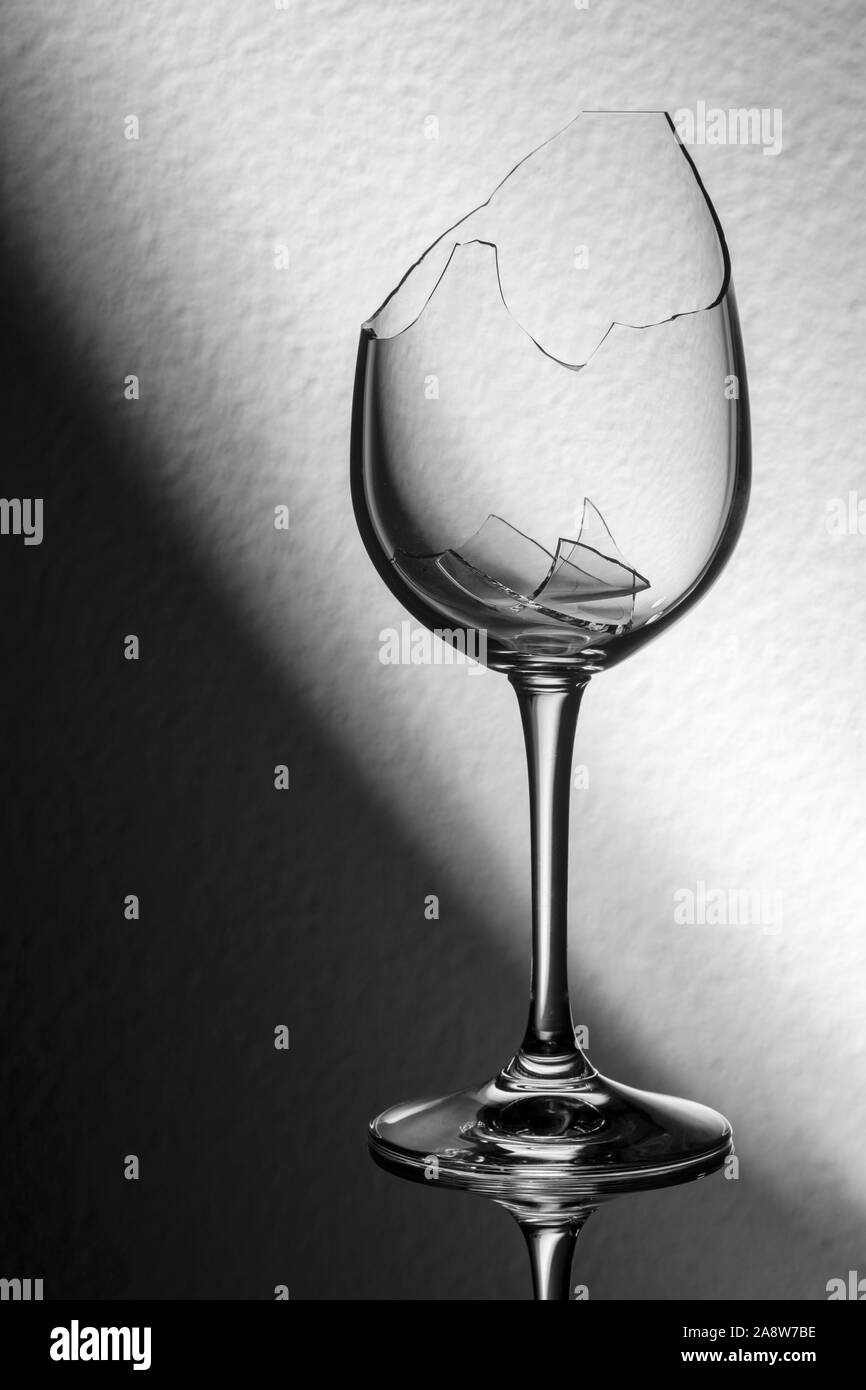 Studio Nahaufnahme einer zerbrochenen Glas Wein mit zerbrochenen Fragmenten vor diagonale Hintergrund. Stockfoto