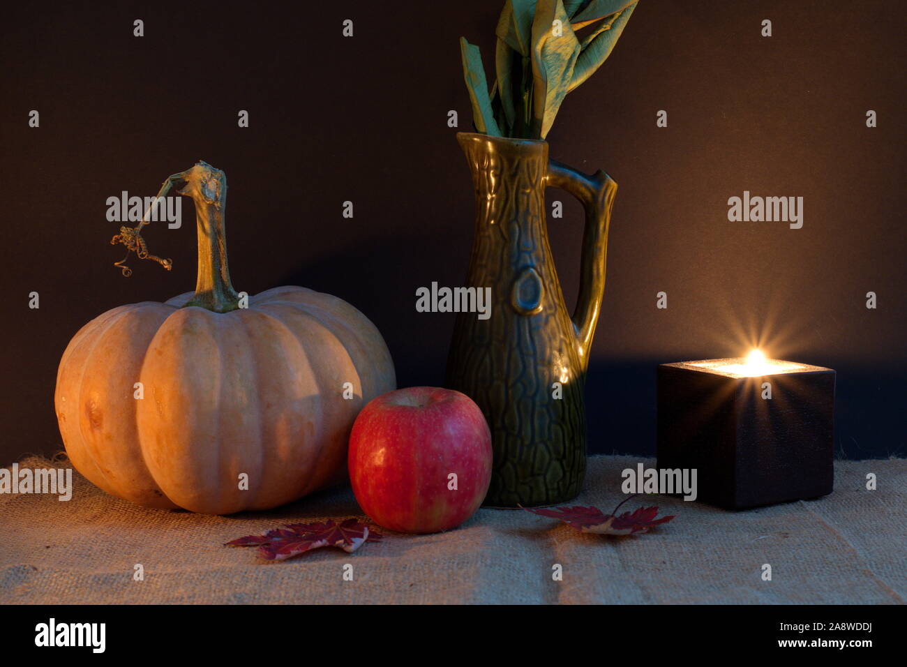 Halloween Dekoration mit Kürbis Apfel, Blätter und die Kerze vor dem dunklen Hintergrund Stockfoto