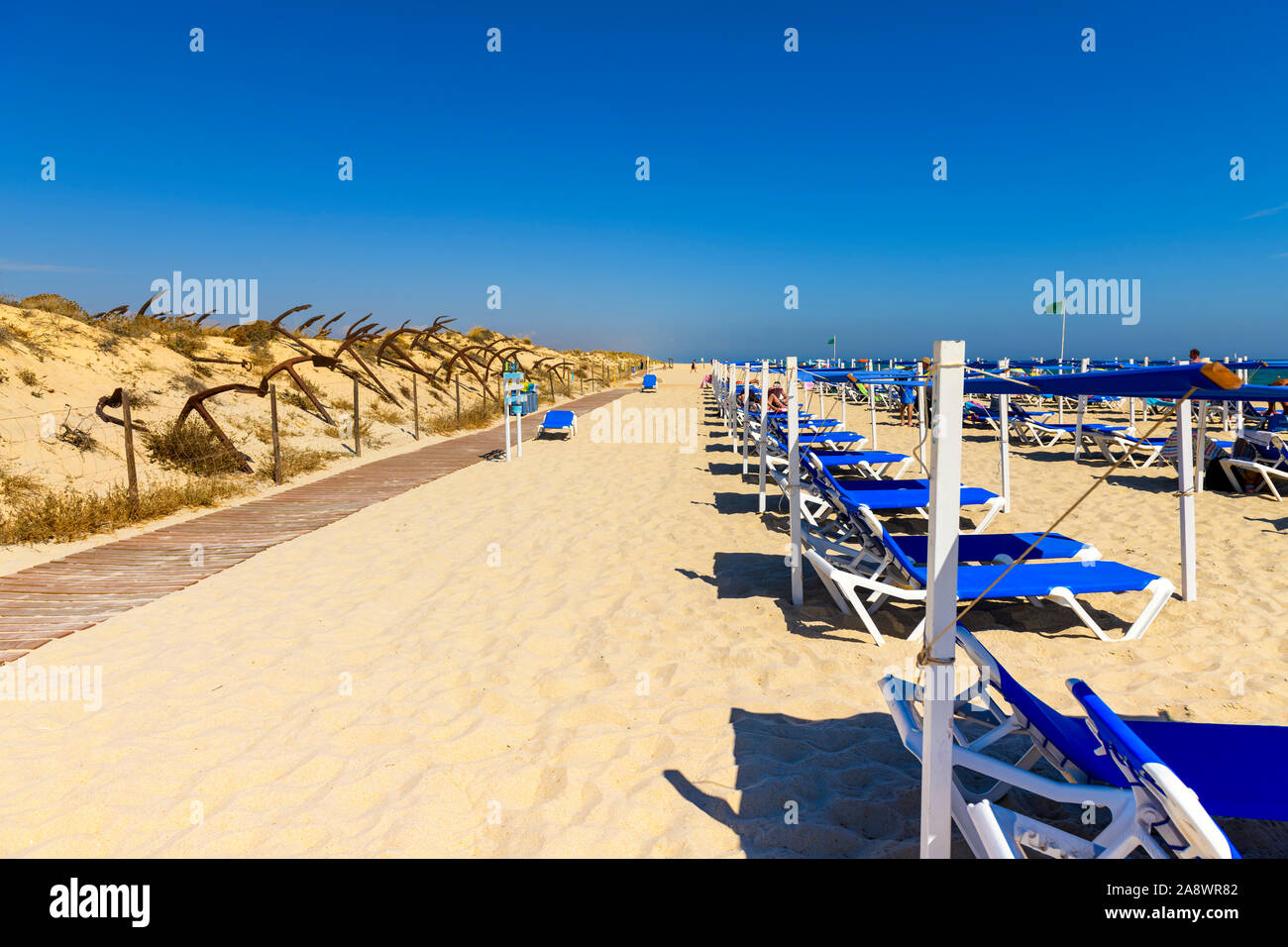 Sonnenliegen am schönen Sandstrand Algarve Barril, Santa Luzia Algarve, Portugal. Stockfoto