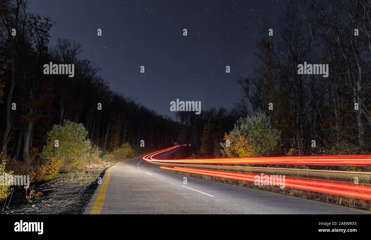 Spuren der Autoscheinwerfer in einer Nacht Straße Stockfoto