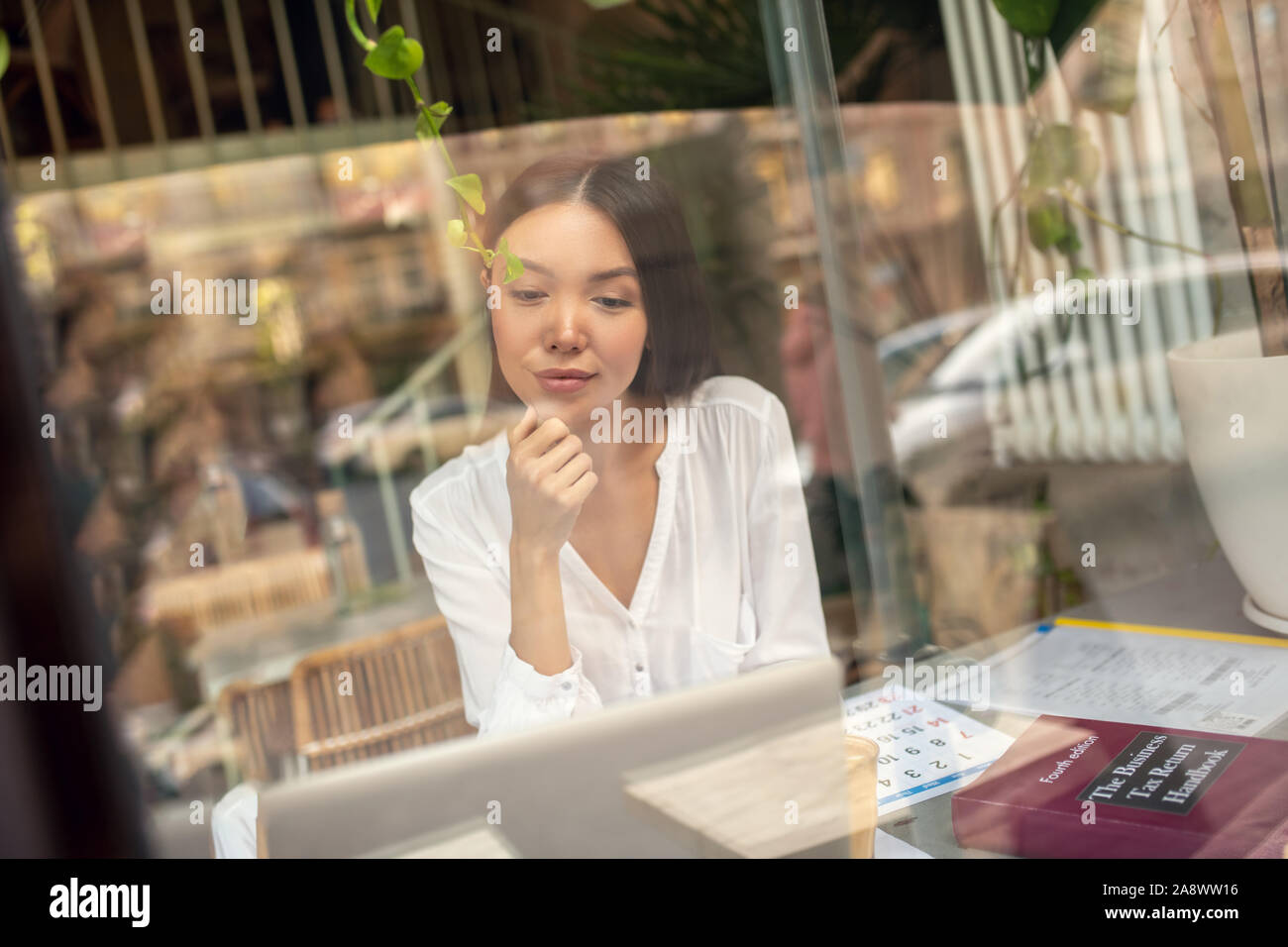 Unternehmer sitzen in der Nähe der Fenster und das Lesen von E-Mails auf Notebook Stockfoto