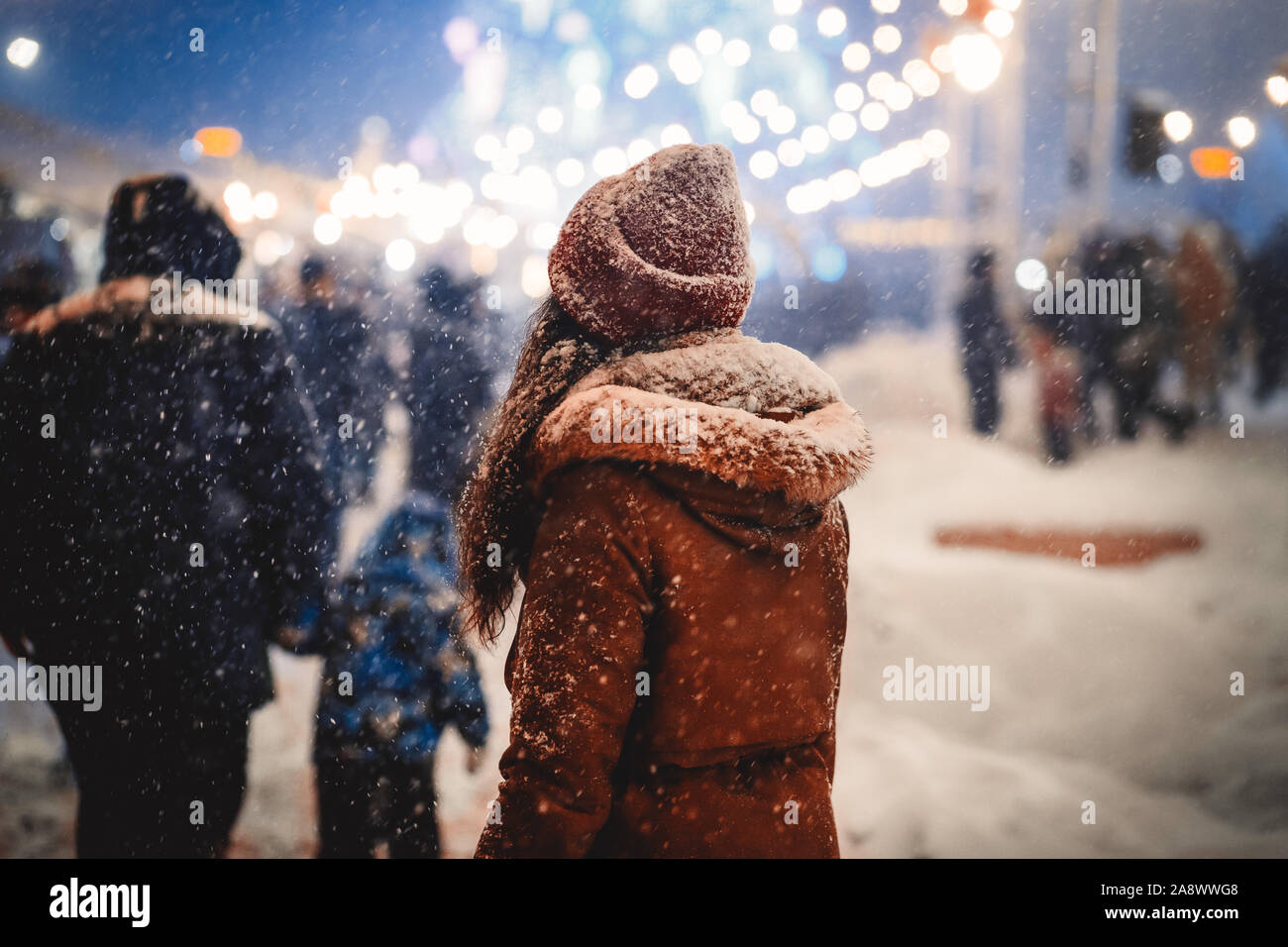Nicht erkennbare Frau zu Fuß durch Weihnachtsmarkt in Night City Stockfoto