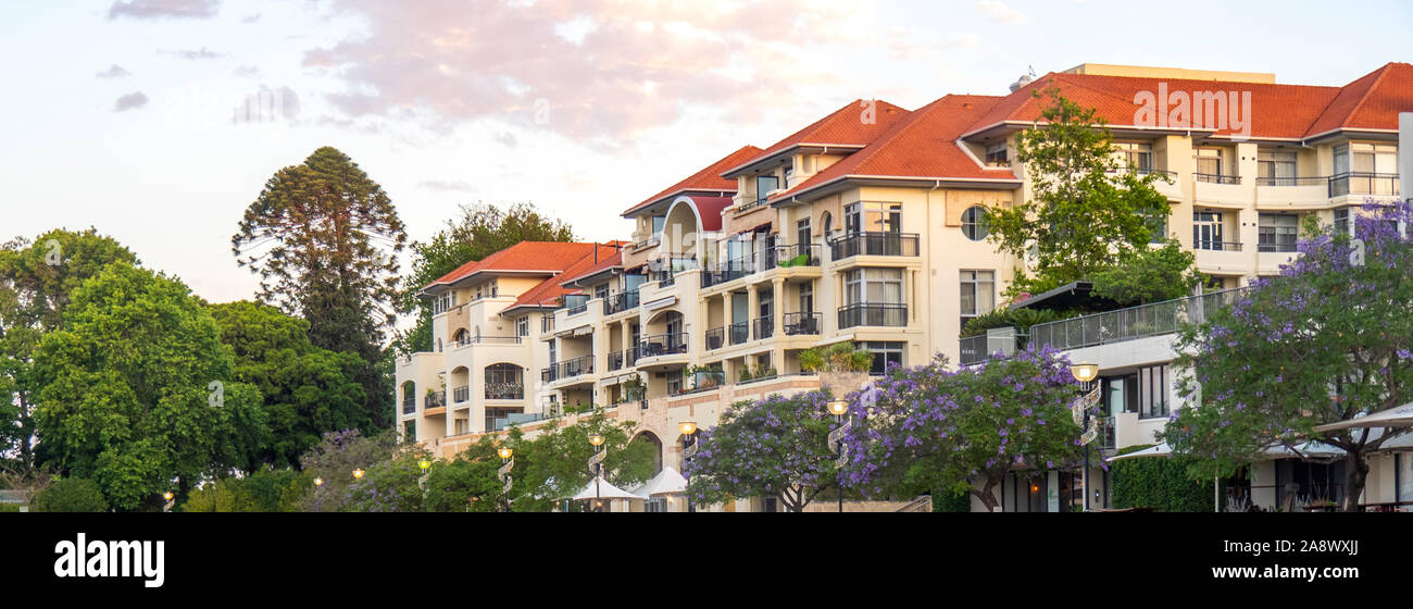 Mehrparteienhaus und Jacaranda Bäumen mit Blick auf Claisebrook Cove East Perth Western Australia. Stockfoto