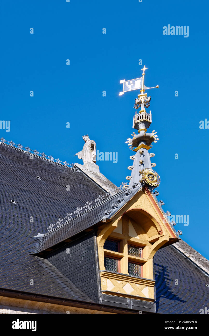 Reich verzierte Dachfenster, Gottesmutter Statue auf dem Dach, Metall peak Dekoration, schwarzen Fliesen, Burgund, Beaune, Frankreich, Sommer, vertikal Stockfoto