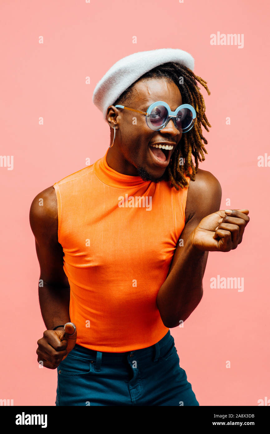 Portrait eines glücklichen jungen Mann lachen und tanzen, Spaß haben, isoliert auf Rosa Stockfoto